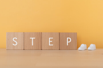 ステップ｜「STEP」と書かれた積み木と靴のおもちゃ