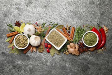 Flat lay composition with different natural spices and herbs on grey table