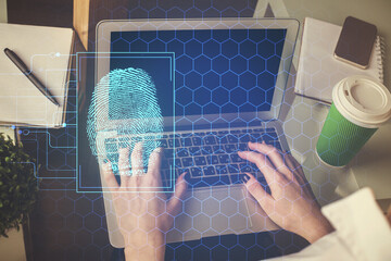 Double exposure of woman hands typing on computer and fingerprint drawing. Security concept.