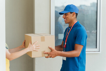 Young African delivery man delivering the package to the customer at the office door.