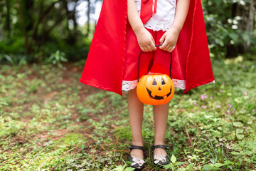 Little Girl in costume of red hat in the park. Happy Halloween concept