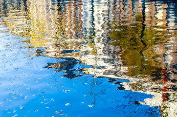 Fototapeta na wymiar Colorful reflection of the buildings along the canal in Amsterdam in the autumn