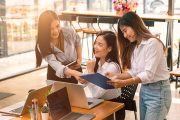 Group of asian young business woman working and communicating while sitting at the office desk together with charts and graphs banner, double exposure successful teamwork,business planning concept.
