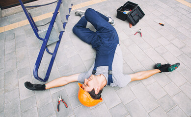 The worker fell down from the ladder while working near the house - obrazy, fototapety, plakaty