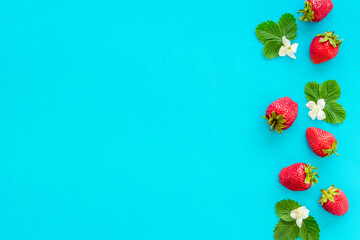 Layout of ripe strawberries with green leaves