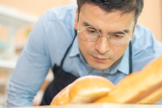 shop owner is checking the quality of the bread before selling it to the customers. Small business quality control