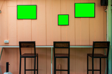 Cafe seating and walls with green boards for advertisements.