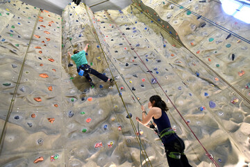 young sporty couple of climbers in a climbing hall