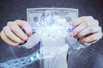 Double exposure of technology drawing hologram and us dollars bills and man hands. Data concept