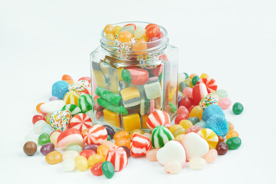 Jar with sweets and candies around on a white background.