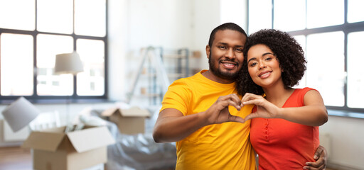 love, valentines day and moving concept - happy african american couple making hand heart gesture over new home background