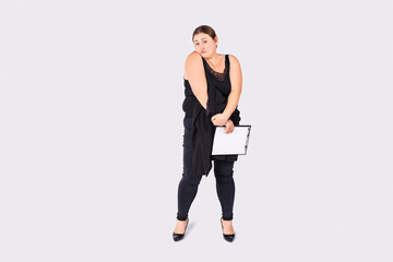 Overweight woman in black clothes with puzzled facial expression holding in her hands document for filling.