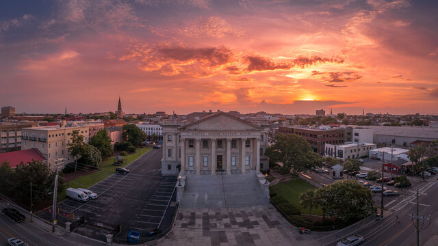 Sunset aerial view of old custom house with classical Greek style columns in the historic center of Charleston South Carolina orange, red dramatic sky background