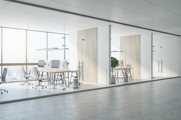 Sunny light spacious office with eco style interior design, light wooden tables for workspace, wooden partitions and glass transparent wall and doors
