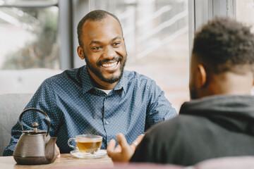Two colleagues having a conversation with a cup of tea during the break