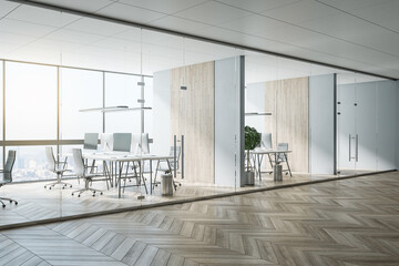 Sunny hall of modern office area with parquet, stylish workspaces, wooden decoration on wall and glass transparent walls and doors