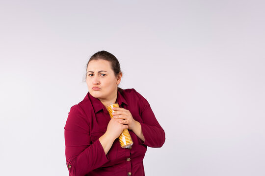 Photo of a one serious fat woman in red dress holding packaging biscuits in her hands so no one can take it.