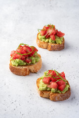 avocado and tomato crostini. Bruschetta toast with mashed avocado
