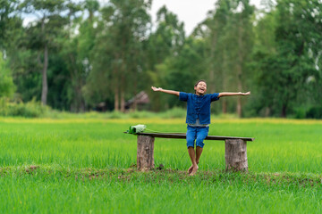 Happy little girl in rice field, countryside of Thailand