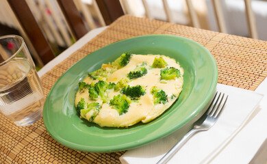 wholesome breakfast. omelet with broccoli on green plate
