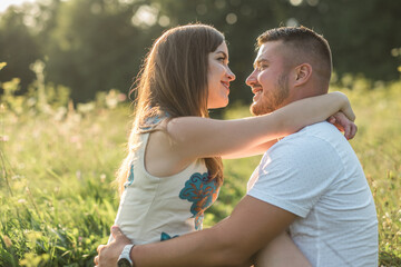 Couple lovers hugging and kissing in the park at sunset. Love, youth, happiness concept.
