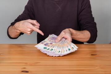 Unrecognizable person showing money from Argentina. Banknotes of 100 pesos.