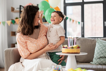 family, holidays and people concept - portrait of happy mother with little son at home birthday party