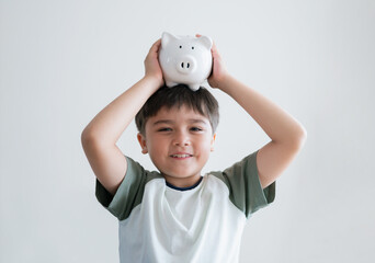 Happy boy putting piggy bank on his head on white background.isolated child with smiling face...