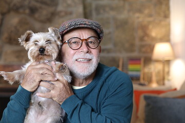 Tender senior man holding Yorkshire terrier