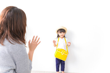 幼稚園に行く子どもと見送るお母さん