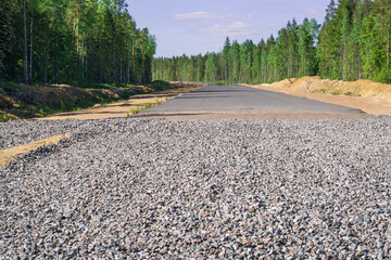 Highway construction. Asphalt paving on gravel and sand