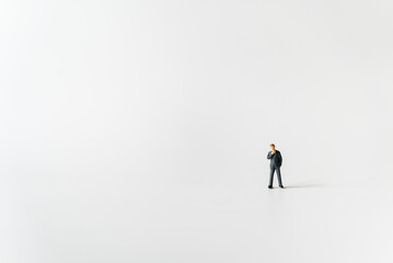 Obraz premium Miniature businessman planning thinking success deal business on white background using as commitment, insurance agreement, travel investment and partnership business development joint venture concept