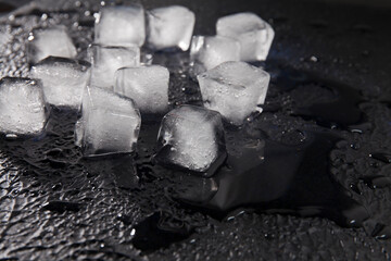 Light ice cubes on dark textured background