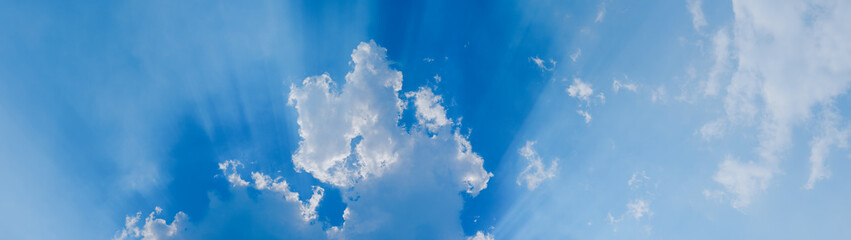 Fototapeta na wymiar Sun rays on cloudy sky banner panoramic