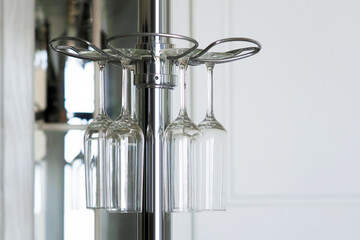 Several clean glasses hanging. Clean glasses for alcoholic beverages over the bar kitchen
