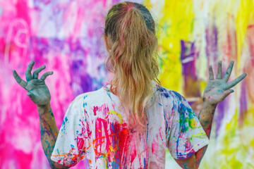 At the festival, the T-shirt is painted with colorful paints. A creative holiday for people. Hands...