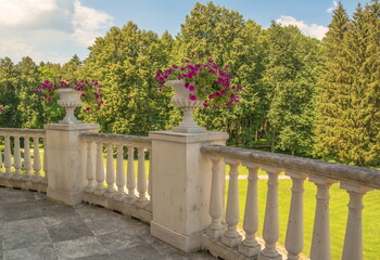 Old terrace decorated with vases of flowers overlooking the park