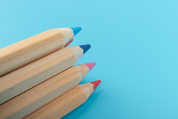 Wooden colorful ordinary pencils isolated on blue background