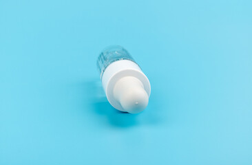 face serum drop with bottle on blue background.