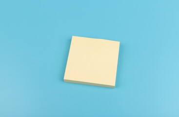 yellow sticky notes on blue background. Square sticky paper reminders with shadows