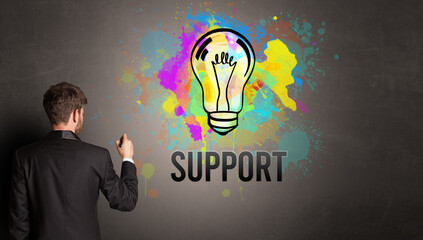 businessman drawing colorful light bulb