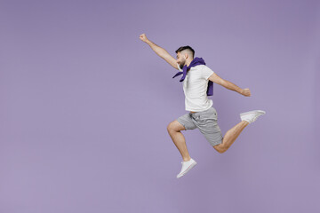 Full size body length side view young brunet man 20s wear white t-shirt purple shirt jumpdoing superman gesture isolated on pastel violet background studio portrait. People emotions lifestyle concept.