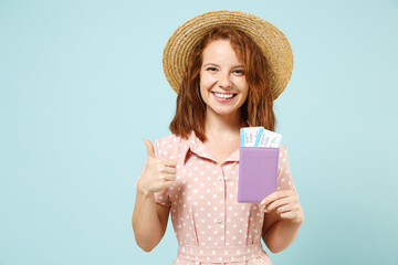 Traveler tourist woman wear summer clothes straw hat hold passport boarding tickets isolated on pastel blue background studio. Passenger travel abroad on weekends getaway. Air flight journey concept.