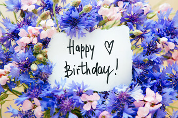 Happy birthday card with greeting words and bouquet of blue cornflower and pink flowers - Powered by Adobe