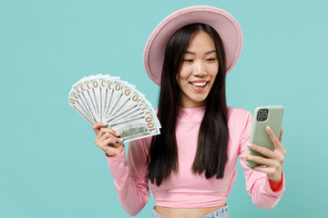 Satisfied smiling happy young brunette asian woman 20s wears pink clothes using mobile cell phone...