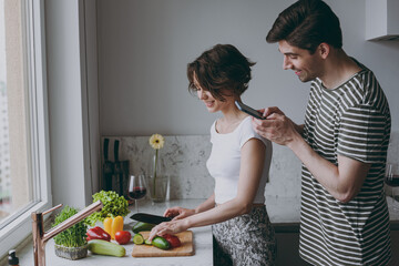 Young side view couple two woman man 20s in casual t-shirt clothes prepare vegetable salad take photo by mobile cell phone cook food in light kitchen at home together Healthy diet lifestyle concept.