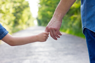 the parent holds the hand of a small child