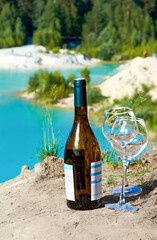 A bottle of wine and glasses on the shore of the blue Bay. The concept of a rest and a picnic and a romantic evening