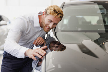 Man happy customer male buyer client wearing white shirt chooses auto wants to buy new automobile...