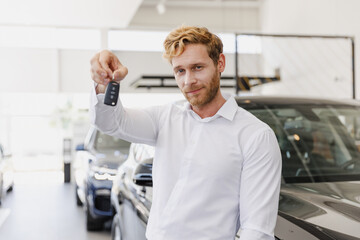 Naklejka na ściany i meble Man happy customer male buyer client wearing classic suit shirt giving keys fob chooses auto want buy new automobile in car showroom vehicle salon dealership store motor show indoor. Sales concept